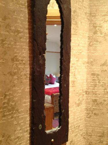 a mirror looking into a room with a bed at Copper Kettle B&B in Killarney