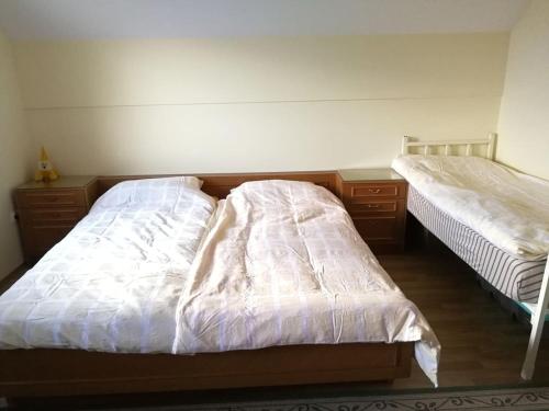 - une chambre avec 2 lits et des draps blancs dans l'établissement Peaceful, cosy cottage near Kolpa river, à Gradac