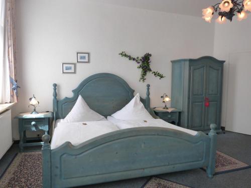 a bedroom with a green bed with white pillows at Hotel Jägerhof in Mayen