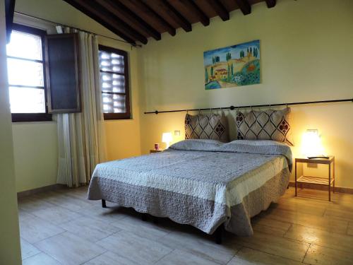 um quarto com uma cama e duas janelas em L'Aia di Argia em Ponte a Tressa
