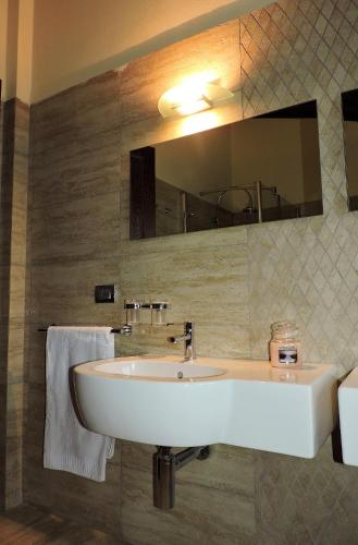 a bathroom with a white sink and a mirror at L'Aia di Argia in Ponte a Tressa