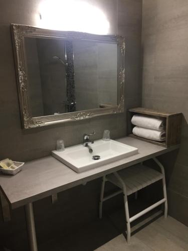 a bathroom with a sink and a mirror and towels at Hôtel Burnichon in Tarare