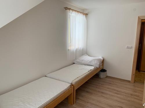 a small room with two beds and a window at Chata Stará Škola in Staré Město