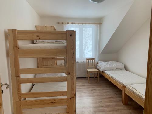 a bedroom with two bunk beds and a window at Chata Stará Škola in Staré Město