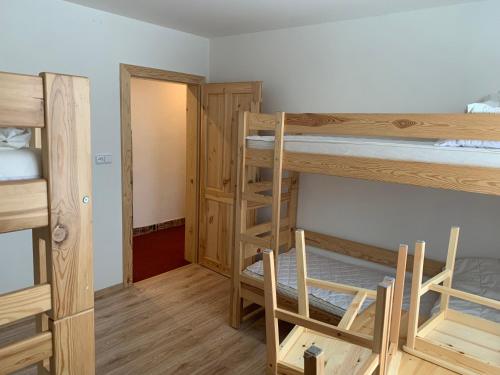 a room with two bunk beds and a hallway at Chata Stará Škola in Staré Město