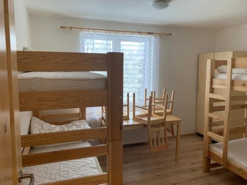 a room with three bunk beds and a desk at Chata Stará Škola in Staré Město