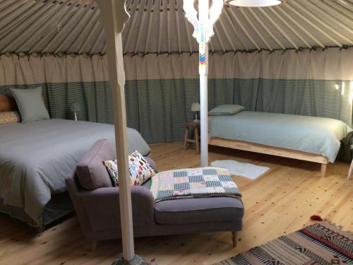 a bedroom with a bed and a couch in a yurt at B&B Le Plat Pays Oostkamp-Brugge in Oostkamp