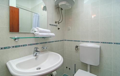a bathroom with a sink and a toilet and a mirror at Apartments Lavica in Podstrana