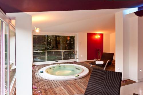 a large tub in a room with a large window at Hotel Villa Rizzo Resort and Spa in San Cipriano Picentino