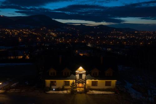 budynek z oświetloną wieżą w nocy w obiekcie Mileżówka - Noclegi&SPA w Ustroniu
