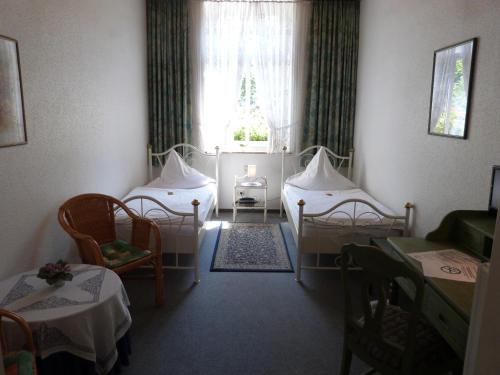 a room with two beds and chairs and a window at Hotel Jägerhof in Mayen