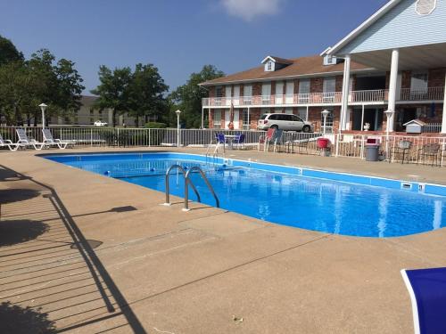 a large blue swimming pool in front of a hotel at Twelve Oaks Inn in Branson