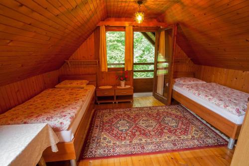an attic room with two beds and a window at PR`Cajhn in Radovljica