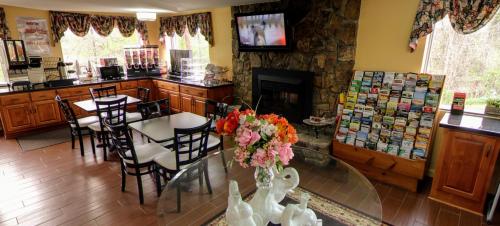 a restaurant with a table and chairs and a fireplace at Dahlonega Mountain Inn in Dahlonega