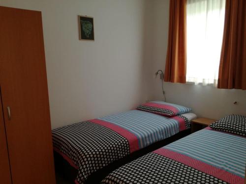 two twin beds in a room with a window at Ivana in Fažana