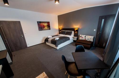 a living room with a bed and a table at Třeboňské Apartmány in Třeboň