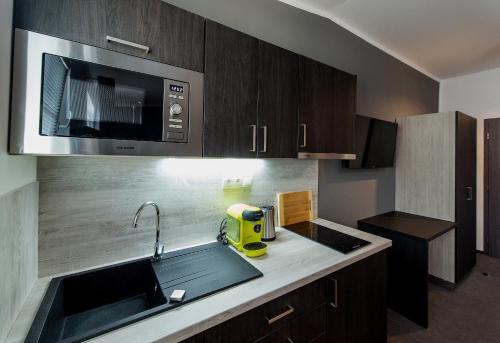 a kitchen with a sink and a microwave at Třeboňské Apartmány in Třeboň