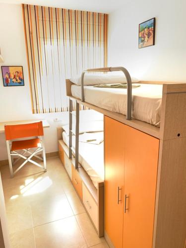 a small room with a bunk bed and a chair at Apartamento Calafell playa in Calafell
