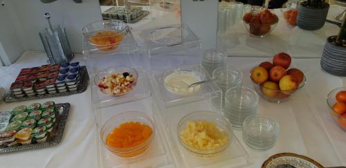 Una mesa cubierta con recipientes de plástico que contienen frutas y otros alimentos. en FeWo Valencia Am Rosenhof - 5 Sterne DTV, en Kühlungsborn