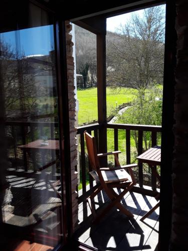 vistas a un porche con una silla y una mesa en Las Rocas, en Vega de Valcarce