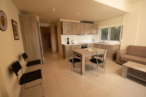 a kitchen and living room with a table and chairs at Seaside Apartment-George in Kaloi Limenes