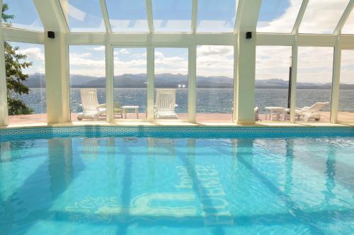 a swimming pool with a view of the water at Hotel Huemul in San Carlos de Bariloche