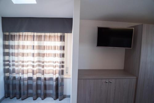 Una televisión o centro de entretenimiento en Hotel Gabbiano