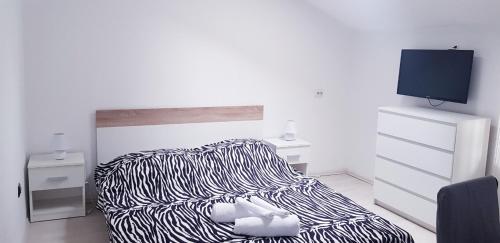 a bedroom with a zebra print bed and a tv at David 3 in Pula