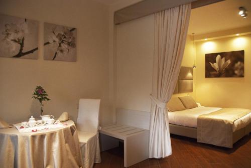 a hotel room with a bed and a table and a bed and a room at Il Portico Luxury B&B in Cassano delle Murge