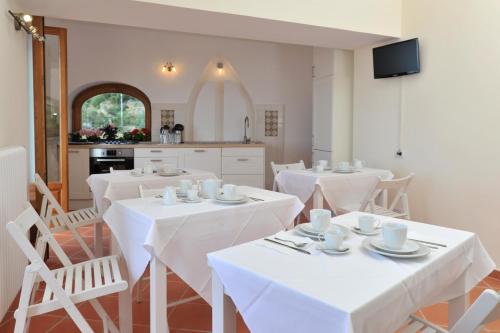 a dining room with white tables and white chairs at Casa Falcone B&B in Scala