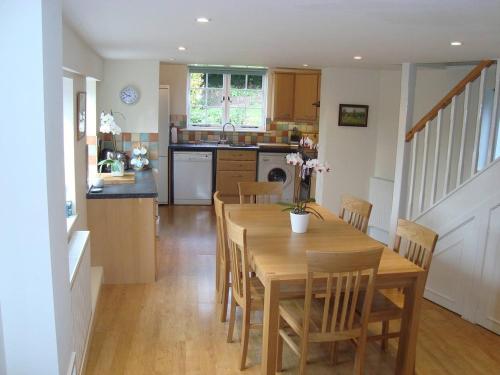 uma cozinha e sala de jantar com uma mesa de madeira e cadeiras em Stunning 3 bedroom self catering cottage near Stonehenge, Salisbury, Avebury and Bath All bedrooms ensuite em Pewsey