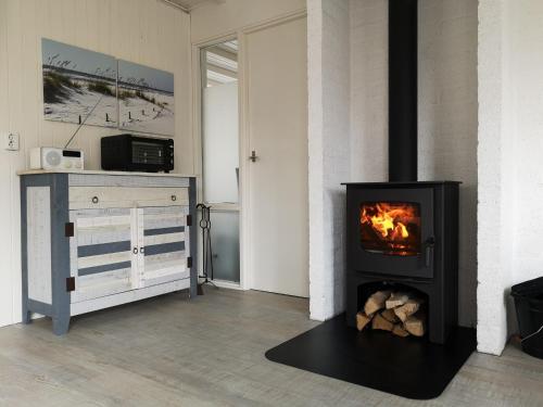 a fireplace in a living room with a stove at De Kastanje Ouddorp in Ouddorp