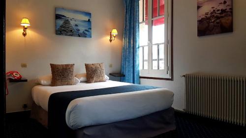Llit o llits en una habitació de Hôtel Le Chantilly