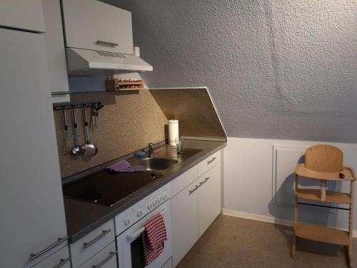 a small kitchen with a sink and a stove at Bramaublick in Hitzhusen