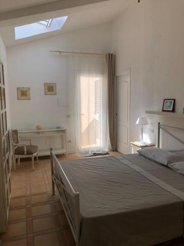 a bedroom with a bed and a desk and a window at Stella d'Argento in Porto Santo Stefano