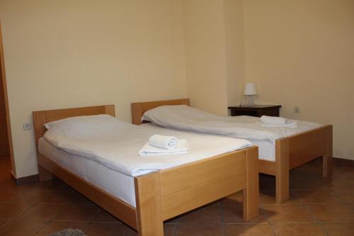 twee bedden in een kamer met handdoeken erop bij Prenoćište "Magnus" in Slavonski Brod