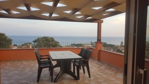 a table and chairs on a balcony with a view of the ocean at Terrazza sul golfo degli angeli in Capitana