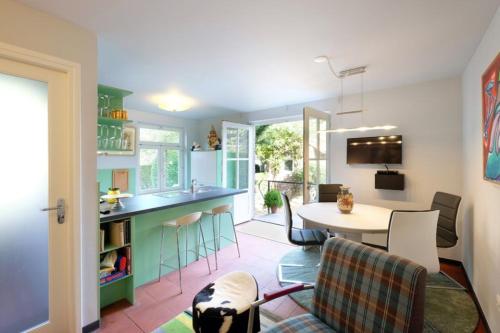 Bie de Borreger في ماستريخت: مطبخ وغرفة معيشة مع طاولة وكراسي