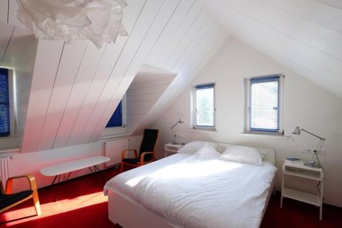 a bedroom with a white bed in a attic at Bie de Borreger in Maastricht