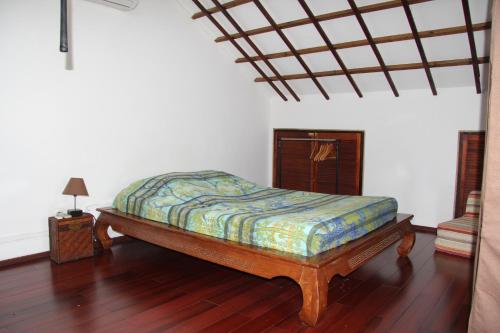 Cama en habitación con suelo de madera en T3 Duplex Meublé Lagon Réunion, en La Saline-Les-Bains