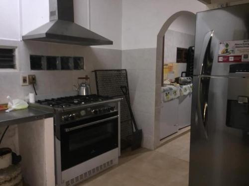 a kitchen with a stove and a refrigerator at Casa de descanso in Colonia Estrella