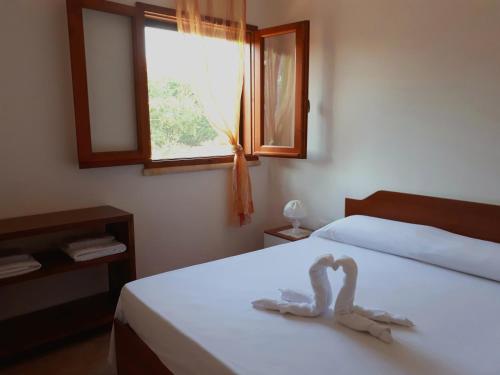 Un dormitorio con una cama con dos cisnes. en Tenuta Cazzato, en Lido Marini