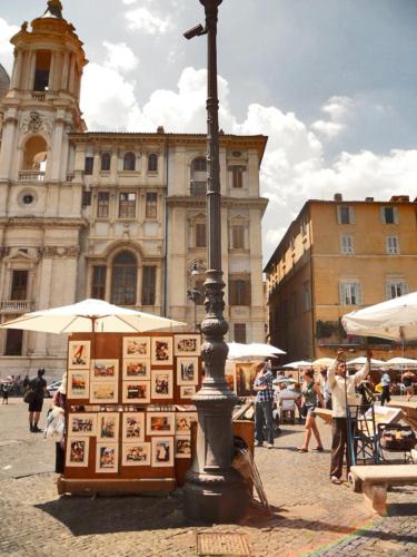 a street pole with a display of pictures in front of a building at Locanda Navona in Rome