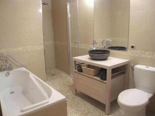 a bathroom with a sink and a tub and a toilet at Chateau Cottage in Carlux