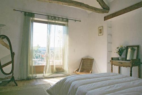 a bedroom with a bed and a large window at Chateau Cottage in Carlux