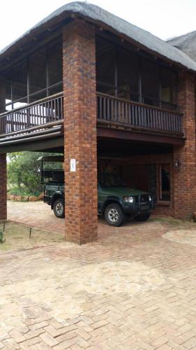 a car parked inside of a brick building with a balcony at Hadeda Lodge, Mabalingwe in Warmbaths