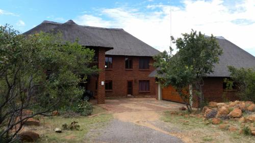 a brick house with a black roof at Hadeda Lodge, Mabalingwe in Warmbaths