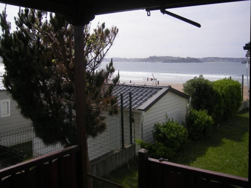 a view of the beach from a house with a fence at Camping Mola! Surf Loredo in Loredo