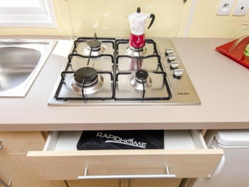 a stove top oven sitting on top of a kitchen counter at Camping Mola! Surf Loredo in Loredo