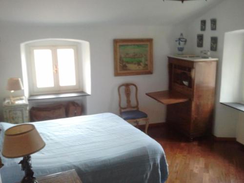 a bedroom with a bed and a window and a chair at un'oasi di tranquillità in Genoa